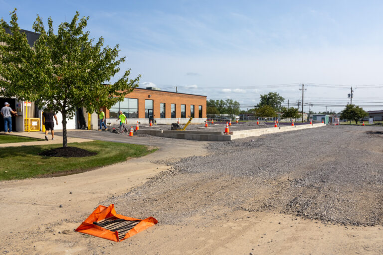 Construction workers prepare the gravel base and concrete foundation outside a Sealing Devices office building.