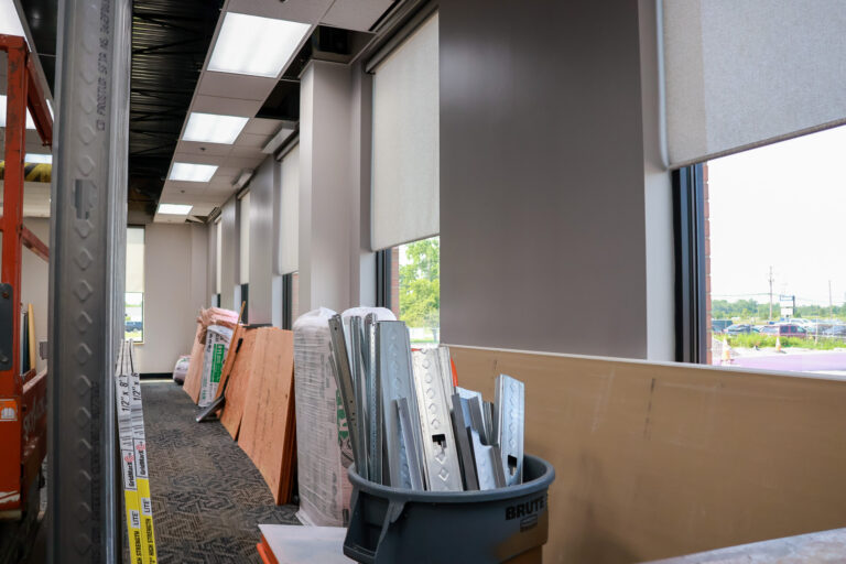 Metal wall studs, drywall, and other materials staged inside a Sealing Devices office renovation.