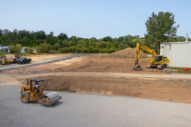 A road roller and excavator prepare the Sealing Devices Lancaster campus expansion site.